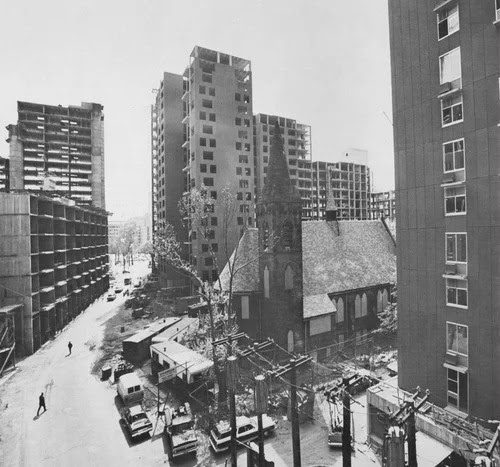 Roosevelt Island's first residential buildings under construction, with the Chapel of the Good Shepherd at center.